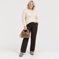 A woman carrying the Debbie Faux Fur Shoulder Bag with Top Handle in Brown