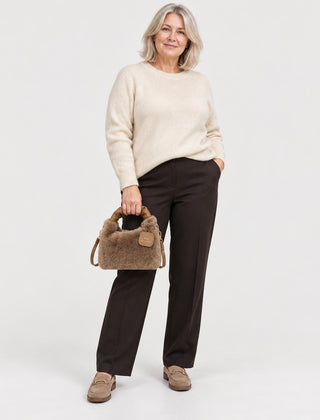 A woman carrying the Debbie Faux Fur Shoulder Bag with Top Handle in Brown