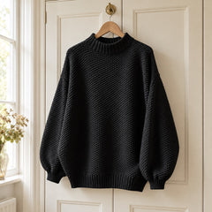 The Irene Textured Mock Neck Knit Jumper in Black on a hanger