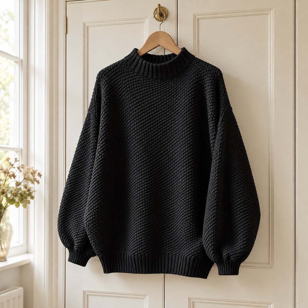 The Irene Textured Mock Neck Knit Jumper in Black on a hanger