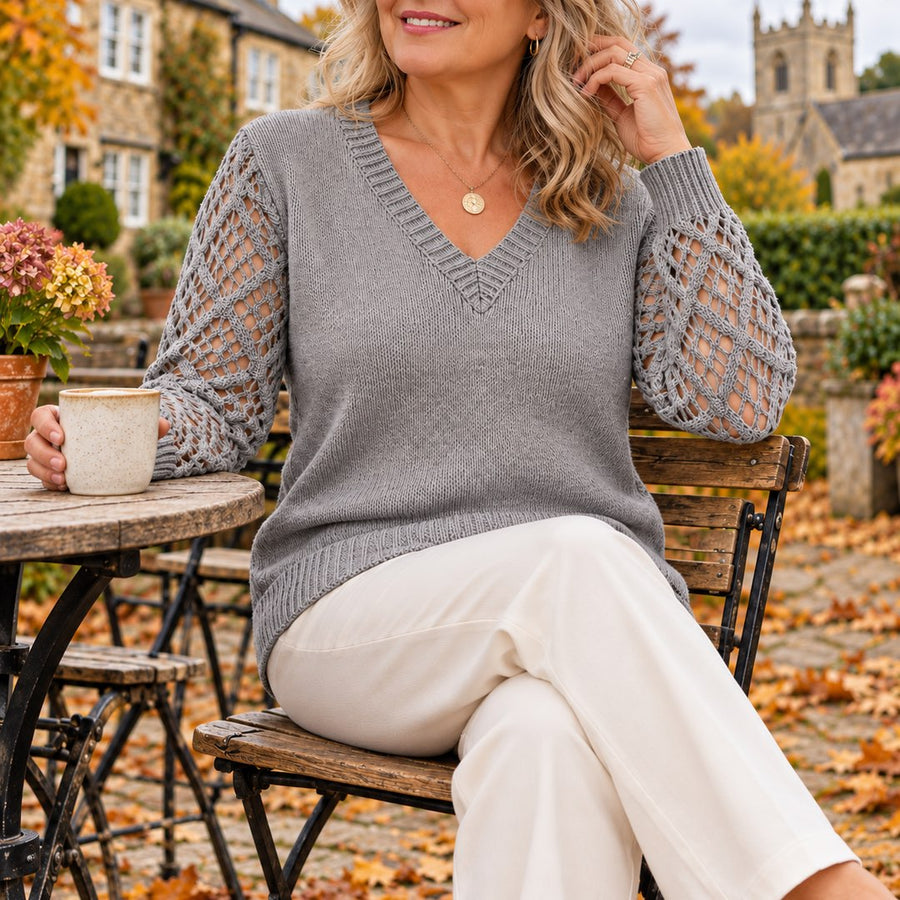A woman wearing the Jeanette Open-Knit Sleeve V-Neck Jumper in Grey