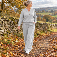 A woman wearing the June Button Neck Jumper and Wide-Leg Trouser Set in Light Grey