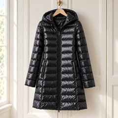 The Karen Lightweight Longline Down Coat with Hood in Black on a hanger