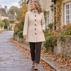 A woman wearing the Kay Stand Collar Tailored Button Coat in Beige