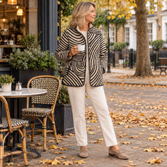 A woman wearing the Lisa Swirl Print Quilted Stand Collar Jacket in Black Cream Swirl