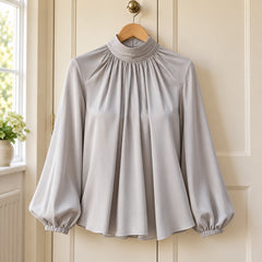 Patsy High Neck Pleated Blouse with Balloon Sleeves in Grey on a hanger